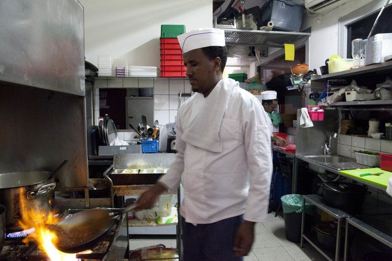 In this Wednesday, Aug. 8, 2018 photo, Eritrean migrant Russom Weldu Weldeslasie works at a restaurant in Tel Aviv, Israel. African migrants coming into Israel have been detained, threatened with deportation, and faced hostility from lawmakers and residents. Now, they face another burden: a de facto 20 percent salary cut that has squeezed them financially and driven them further into poverty. Image by Caron Creighton. Israel, 2017.