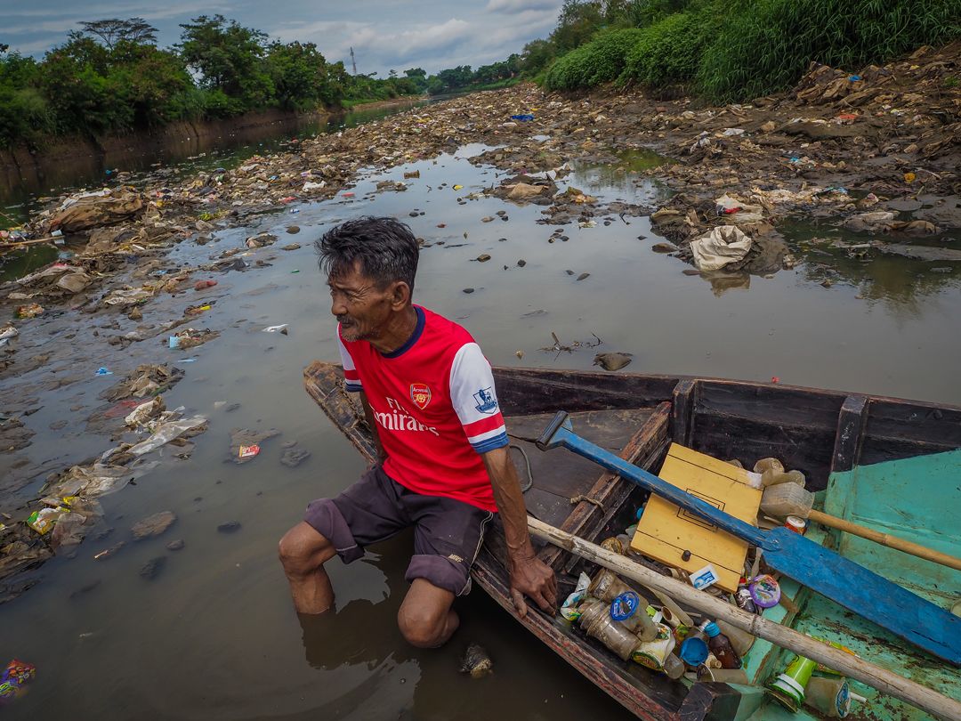 Deni Riswandani scavenges for recyclable trash on the Citarum River. Image by Larry C. Price. Indonesia, 2016.