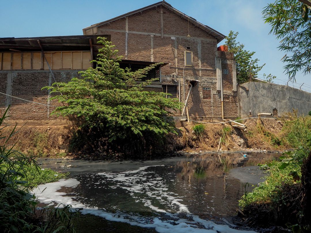 Waste products from textile mills at Rancaekek, Indonesia, flow from factory buildings into the nearby Cikijing River, one of the sources of the Citarum. Image by Larry C. Price. Indonesia, 2016.