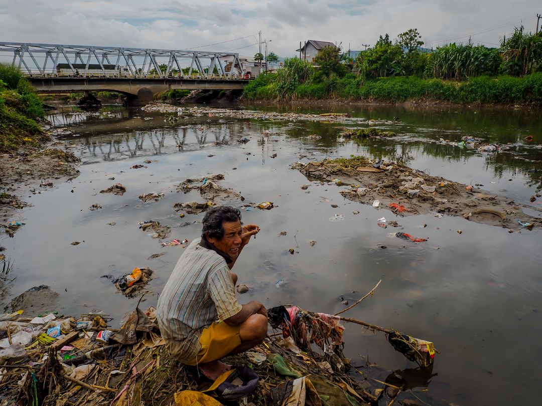 A trash picker works on the Citarum River. Image by Larry C. Price. Indonesia, 2016.