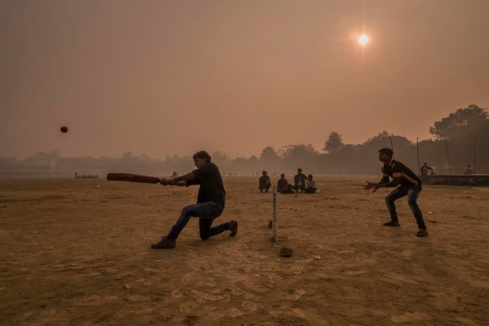 Surrounded by a thick layer of pollution that settled over Patna overnight, a dawn cricket match gets underway at Gandhi Maidan Park in central Patna. Image by Larry C. Price. India, 2018. 