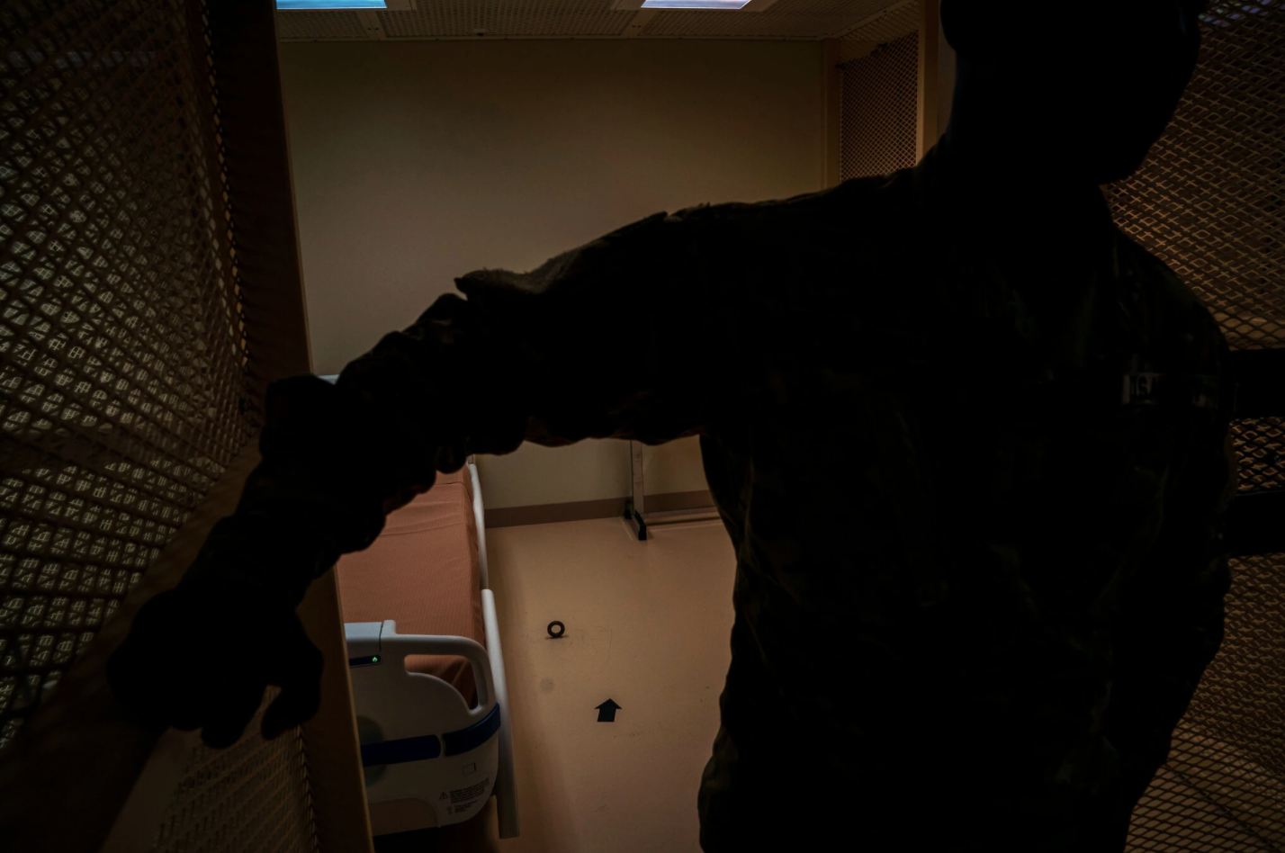 A hospital room at Guantánamo Bay includes a shackle point in the floor and an arrow pointing to Mecca. By law, detainees must receive all their medical care on the base. Image by Doug Mills/The New York Times. United States, undated.