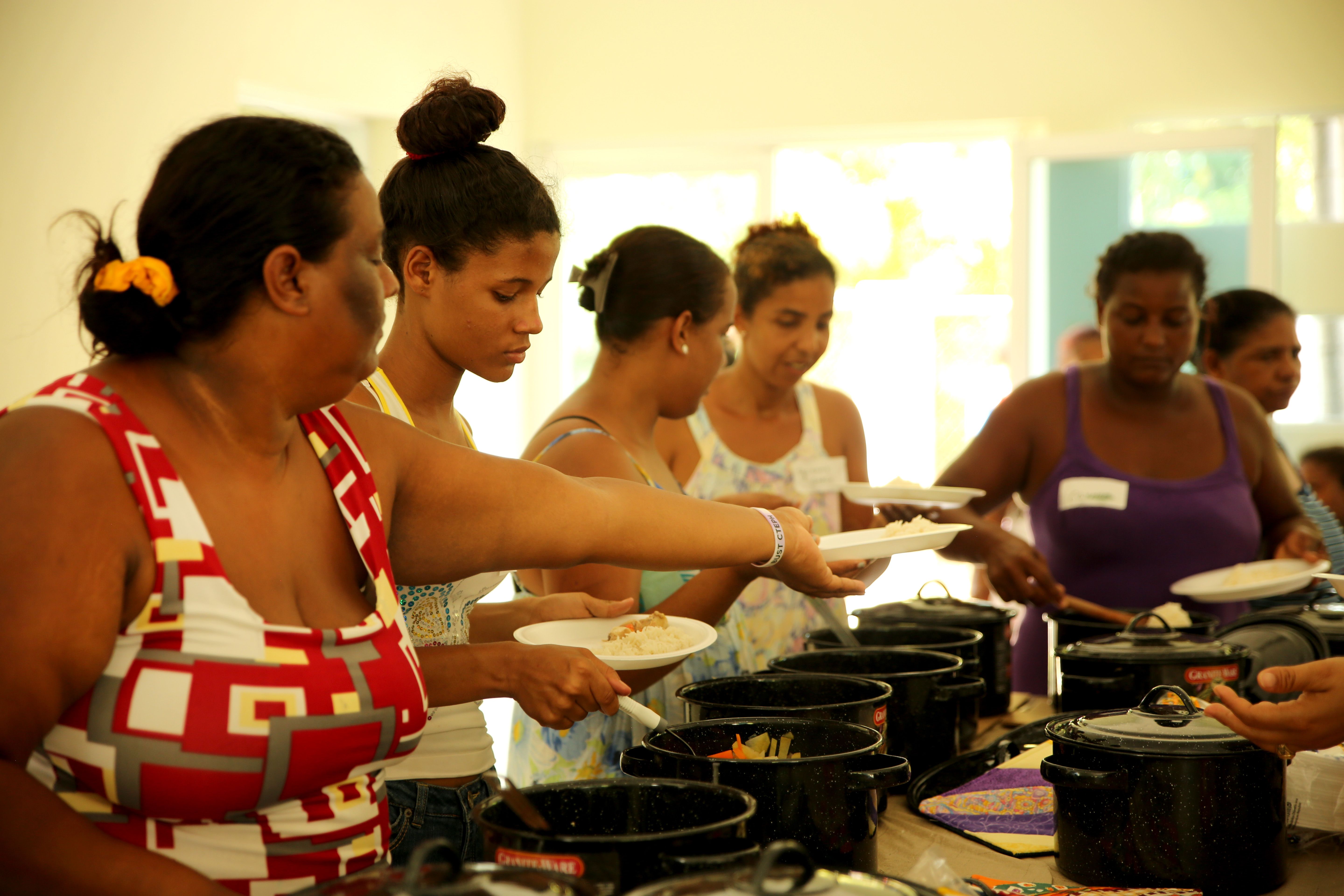 Women serve food from solar oven workshop