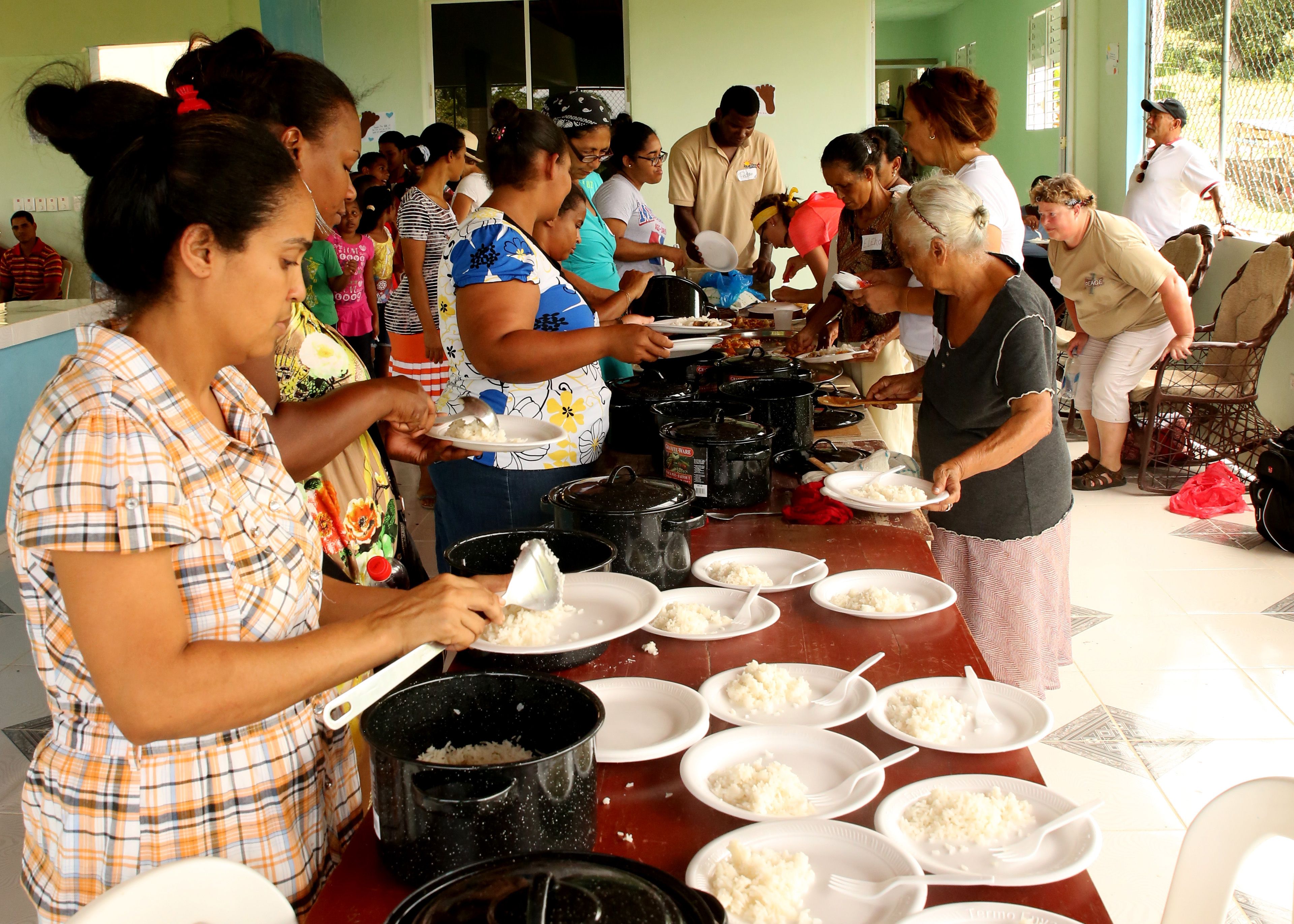 Villa Megarnte community members line up for food