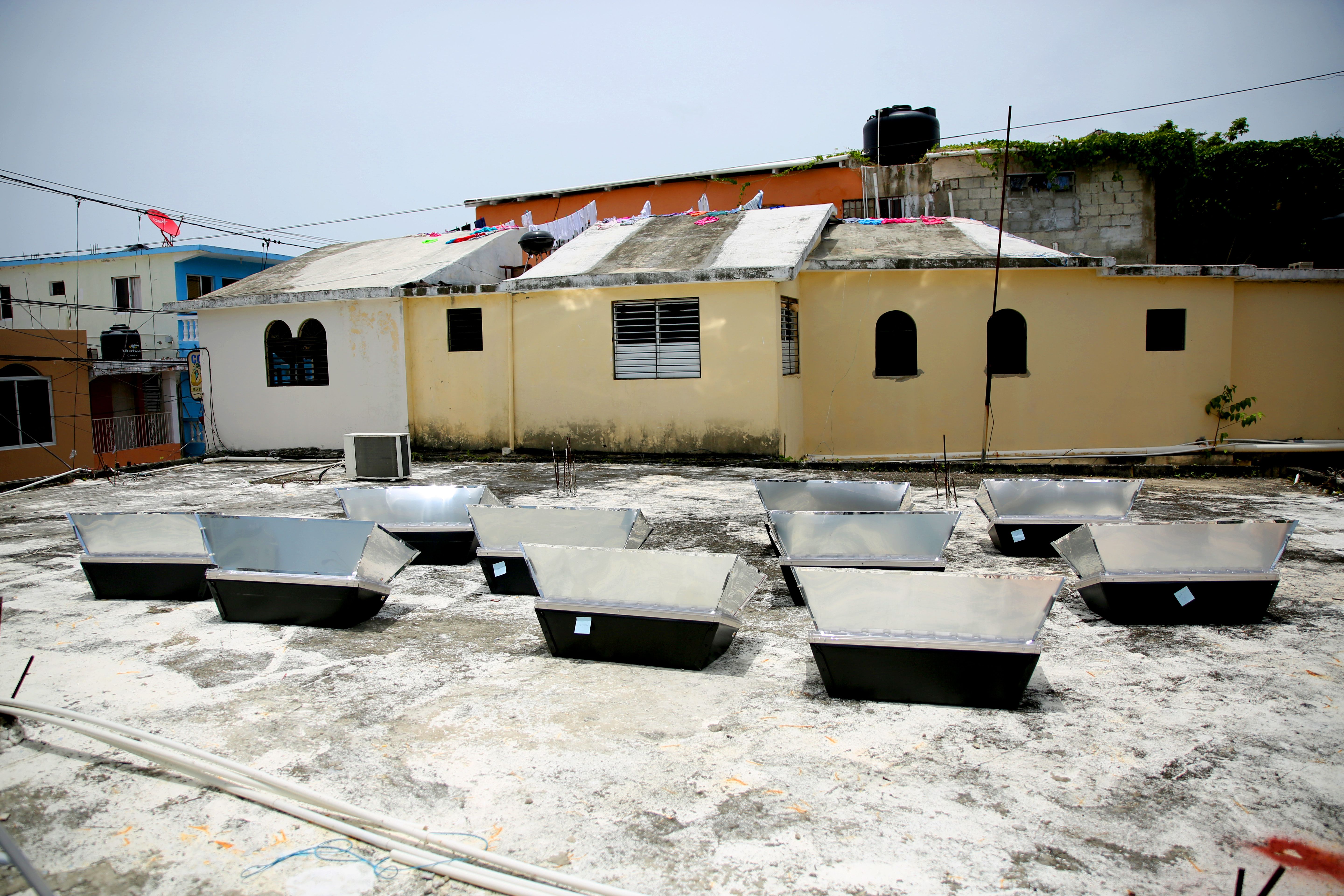 Solar ovens cook atop a Sosua rooftop