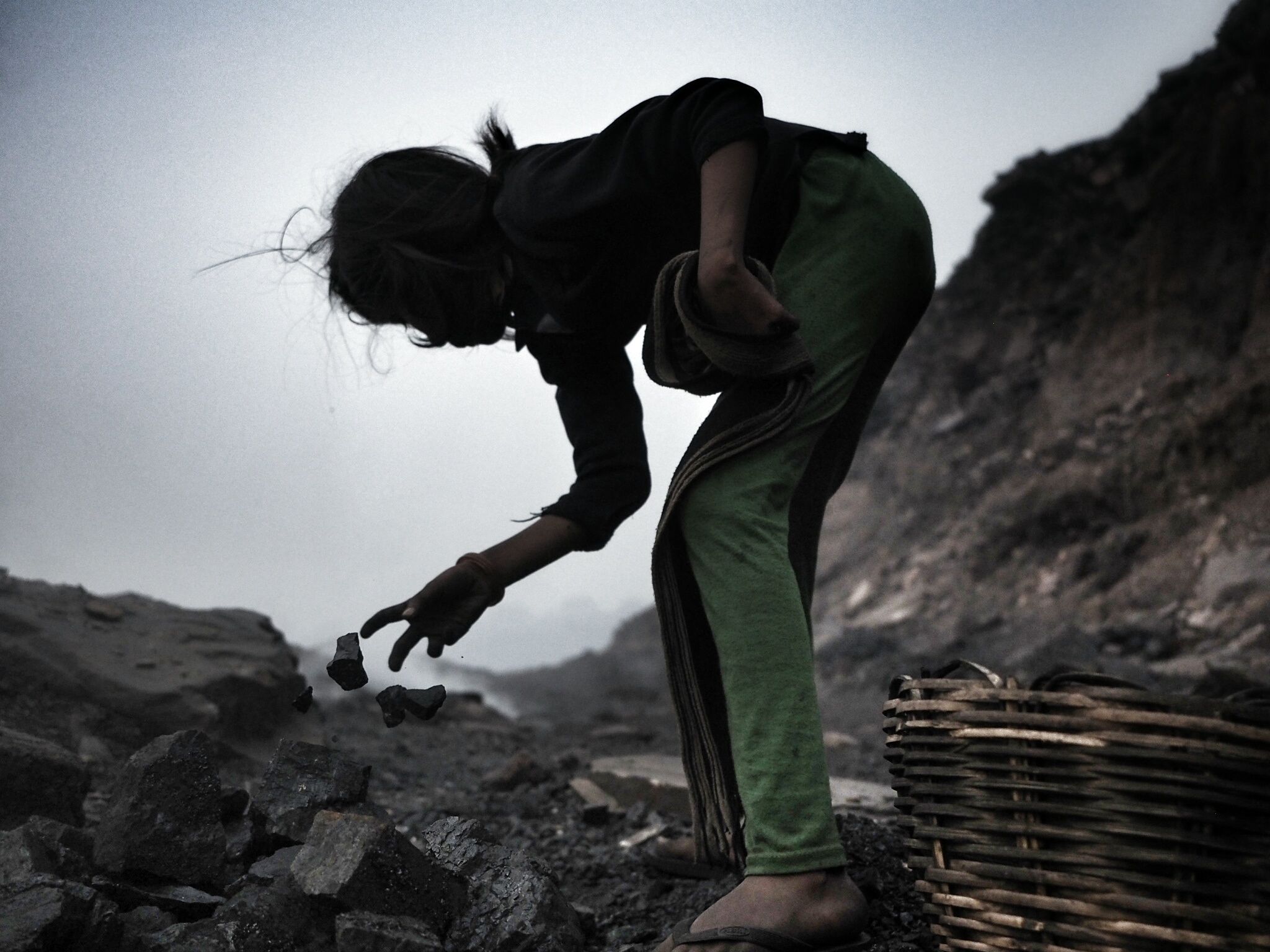 A young girl picks through a coal bed at the Alkusha mine.
