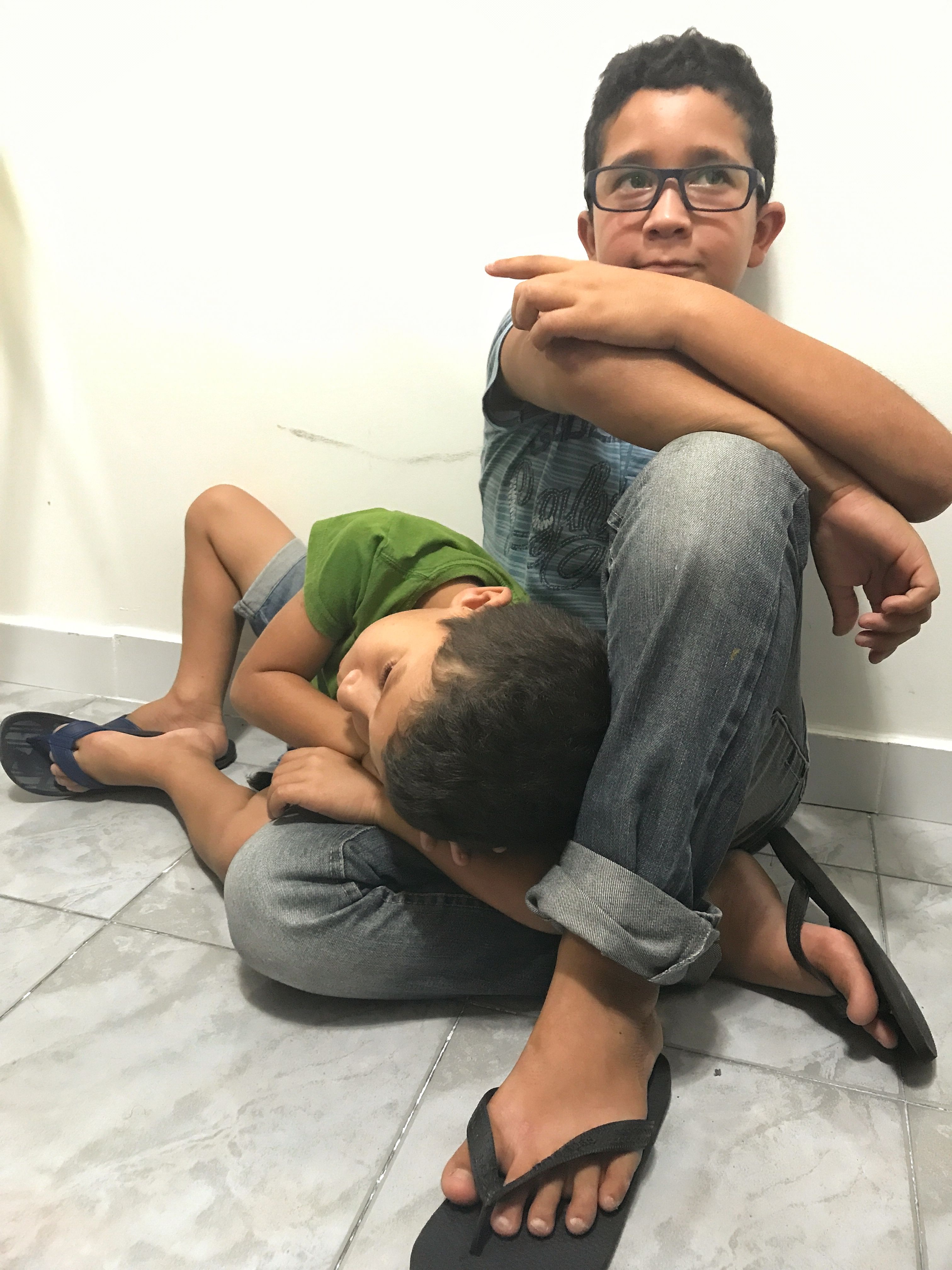 Jorge, 6, lays on his older brother’s lap while they wait for Gilberto to finish his physical therapy appointment at the IPESQ clinic. Dr. Adriana Melo, an obstetrician who rose to national prominence in 2015 after being the first person to isolate the Zika virus in the amniotic fluid of pregnant patients, tells me that “last week when Jorge came to the clinic, he said to me, ‘Doctor, I have microcephaly!’ He asked if he could have the same milk and medications as Gilberto. He wants to feel special, too.” Image by Poonam Daryani. Brazil, 2017.