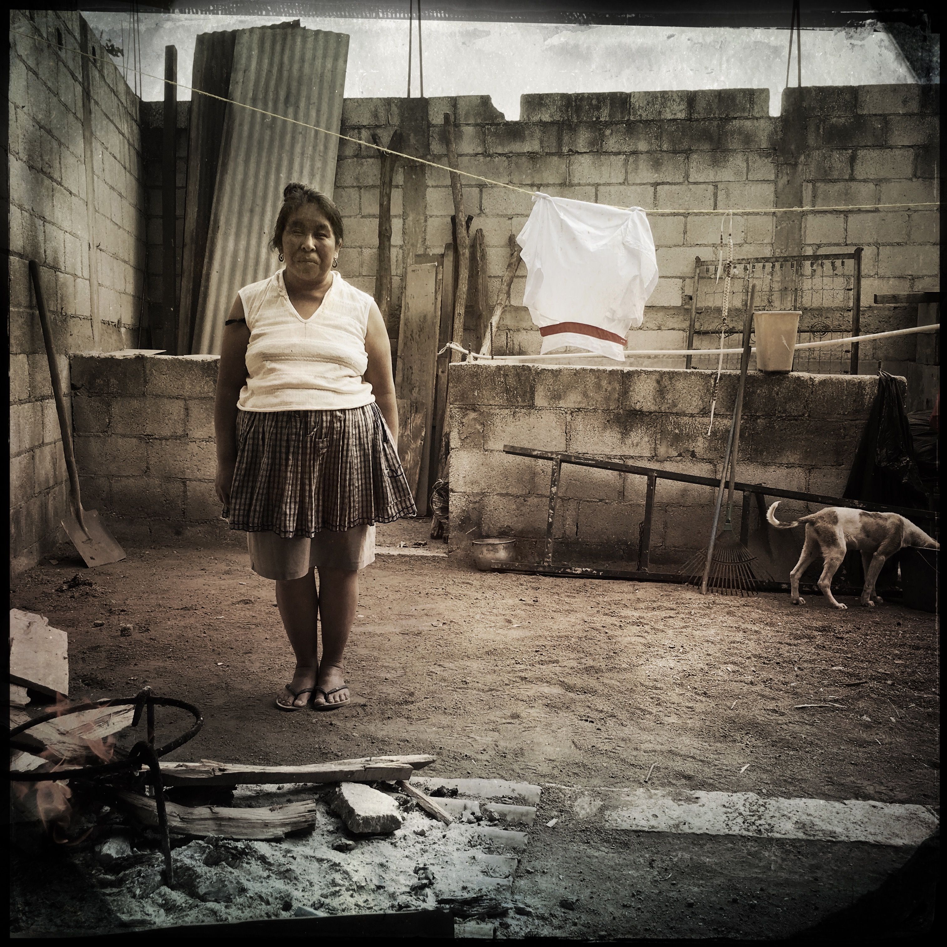 In San Antonio Aguas Calientes, Guatemala, Maria Ermelinda Lopez Mendoza stands near the cooking area in her courtyard. Photo by Lynn Johnson. Guatemala, 2017.