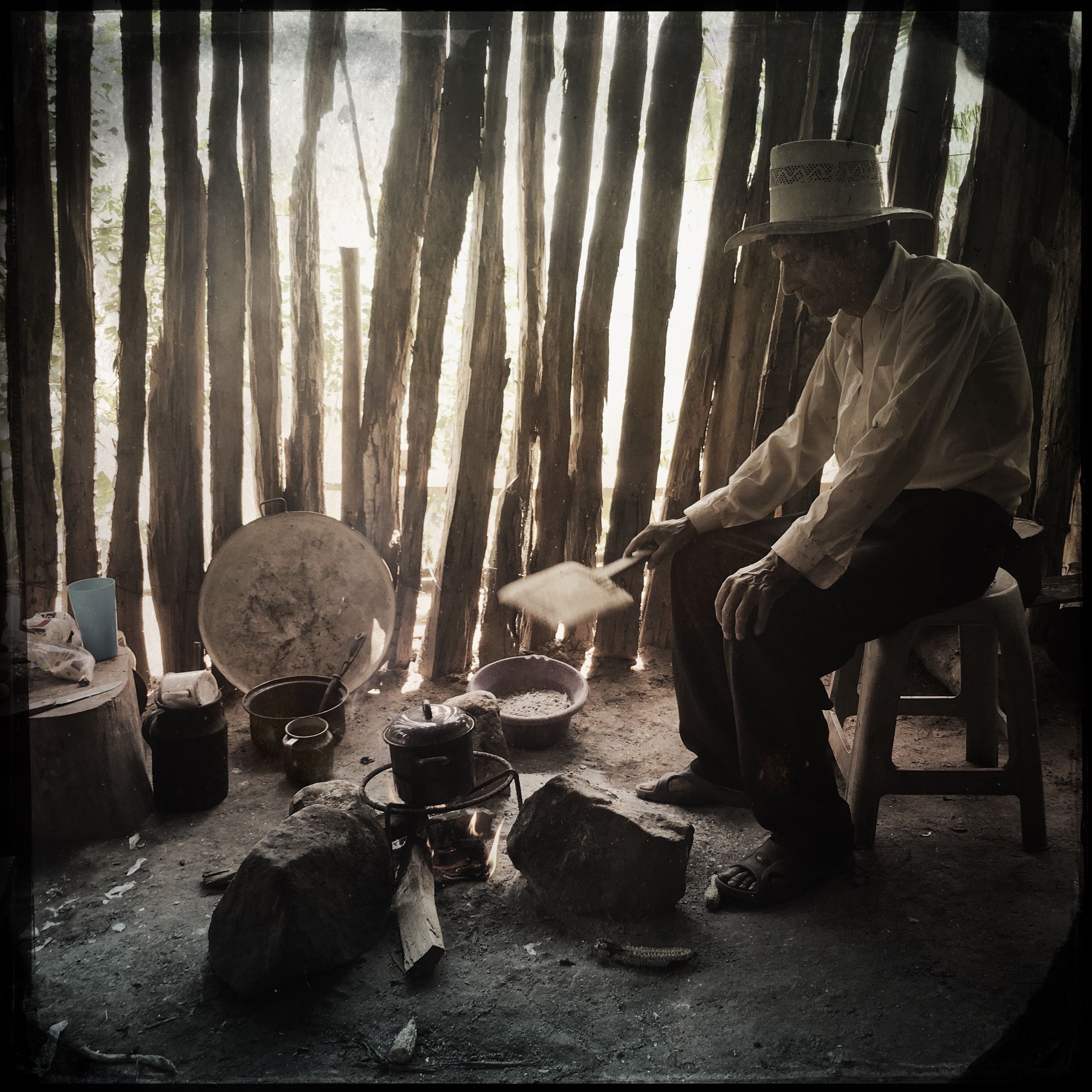 In San Ramon, in southern Guatemala, an elderly man cooks over an open fire. He and his neighbors recently moved here from the Rio Squisal valley, near the border with Mexico, in search of better farmland. Photo by Lynn Johnson. Guatemala, 2017.