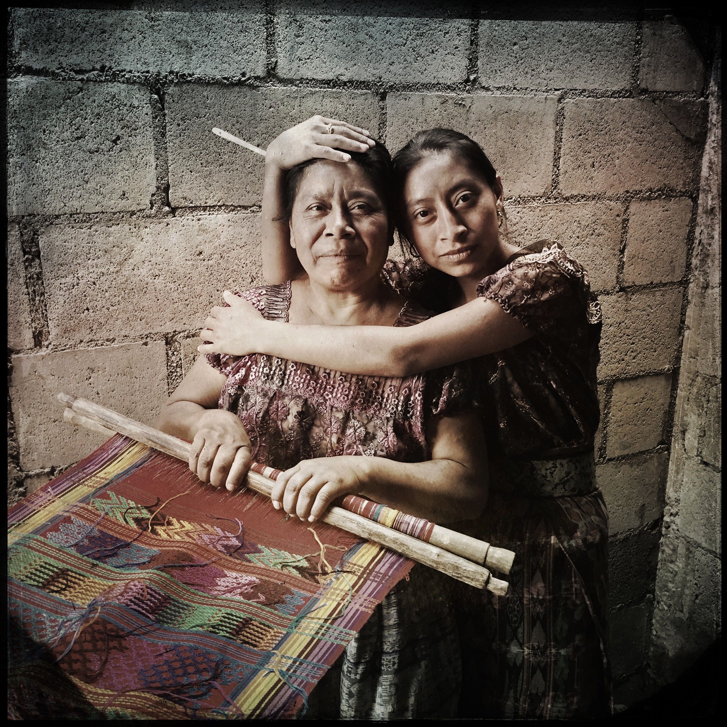 Augustina Lopez Lopez and her daughter, Jessica Roxana Lopez Lopez, of San Antonio Aguas Calientes, Guatemala, recently received an efficient wood-burning stove from the aid group Stove Team International. The air in the kitchen where Augustina weaves is less smoky now, but on some days her eyes are still badly irritated. Photo by Lynn Johnson. Guatemala, 2017.