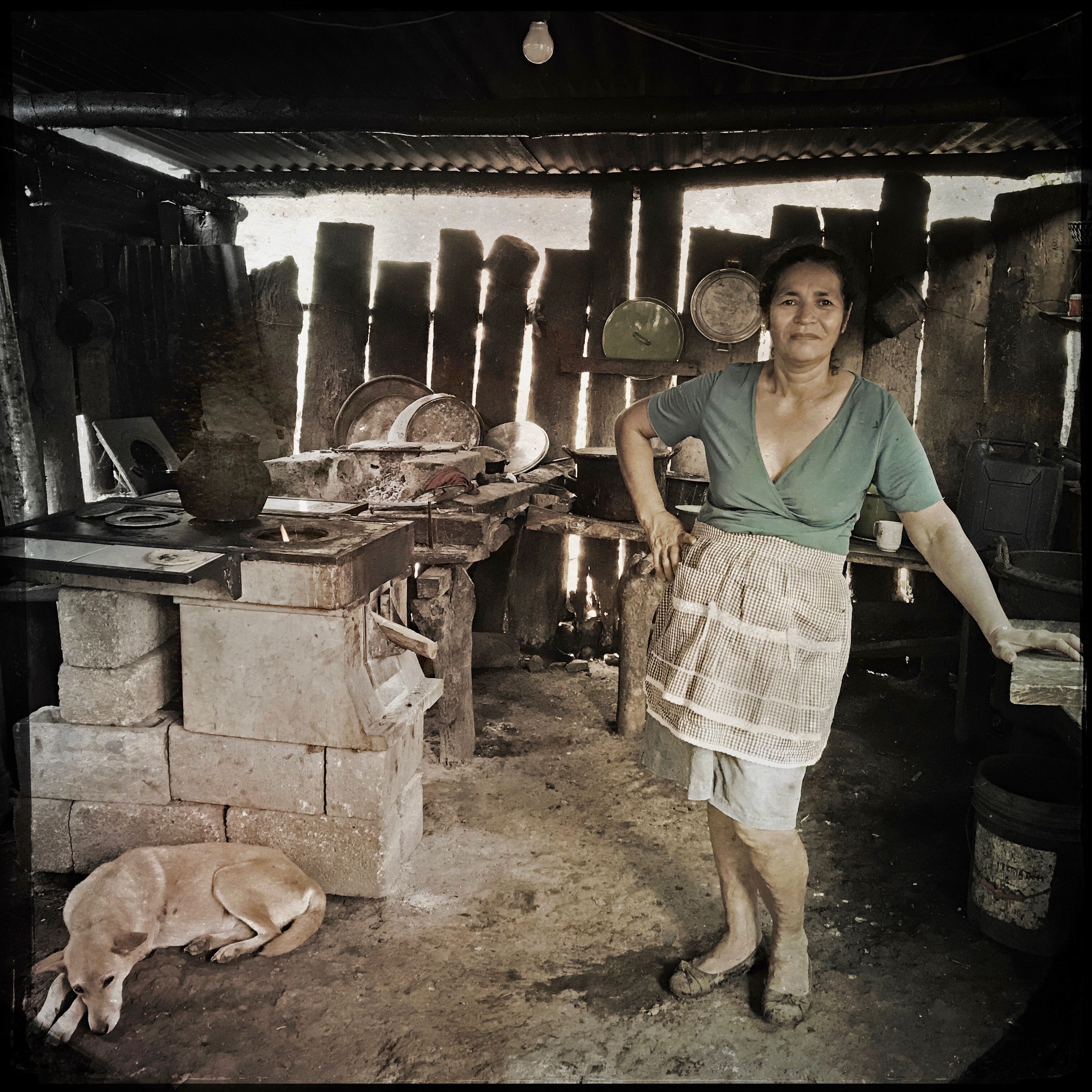 In Las Brisas, Guatemala, a woman stands proudly next to her efficient cookstove, which was donated to her by the aid group Stove Team International. In the developing world, health problems from household smoke inhalation are a significant cause of death in both children under five and women. Photo by Lynn Johnson. Guatemala, 2017.