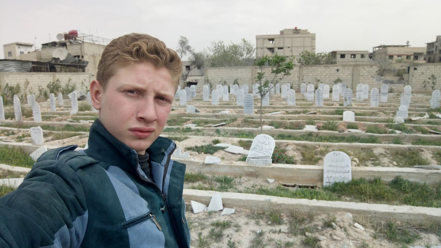 Muhammad Najem visits the tomb of his father one final time before being evacuated from Eastern Ghouta. Image courtesty of Muhammad Najem/Facebook. Syria, 2018.