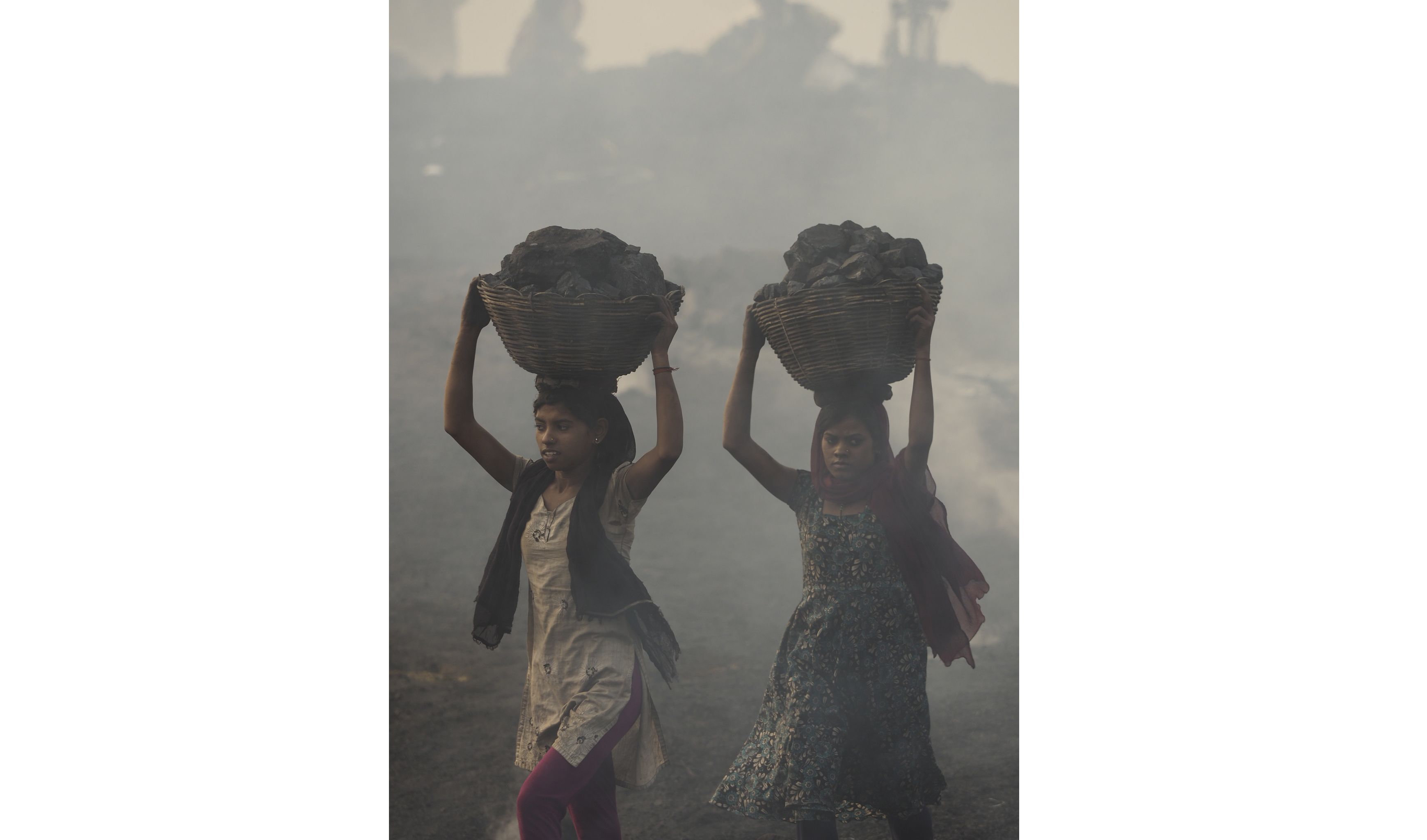 Women carry scavenged coal from the bottom of the Alkusha Coalfield. Image by Larry C. Price. India, 2016.