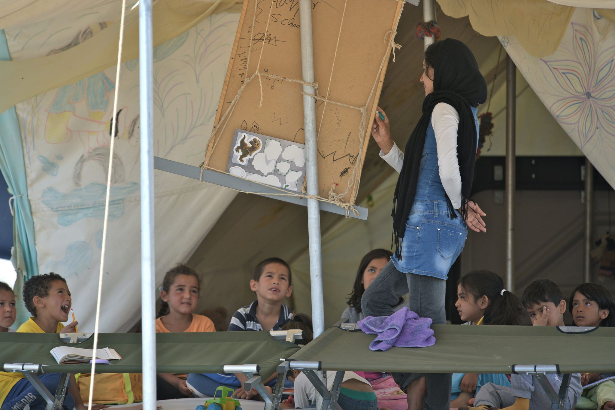 Some of the residents held make-shift educational sessions for children living in the camp. The only book they had is a Arabic-German language textbook, which was ferried over mountains and seas from Afghanistan by one of the camp residents. Image by Frederick Atax. Greece, 2016.