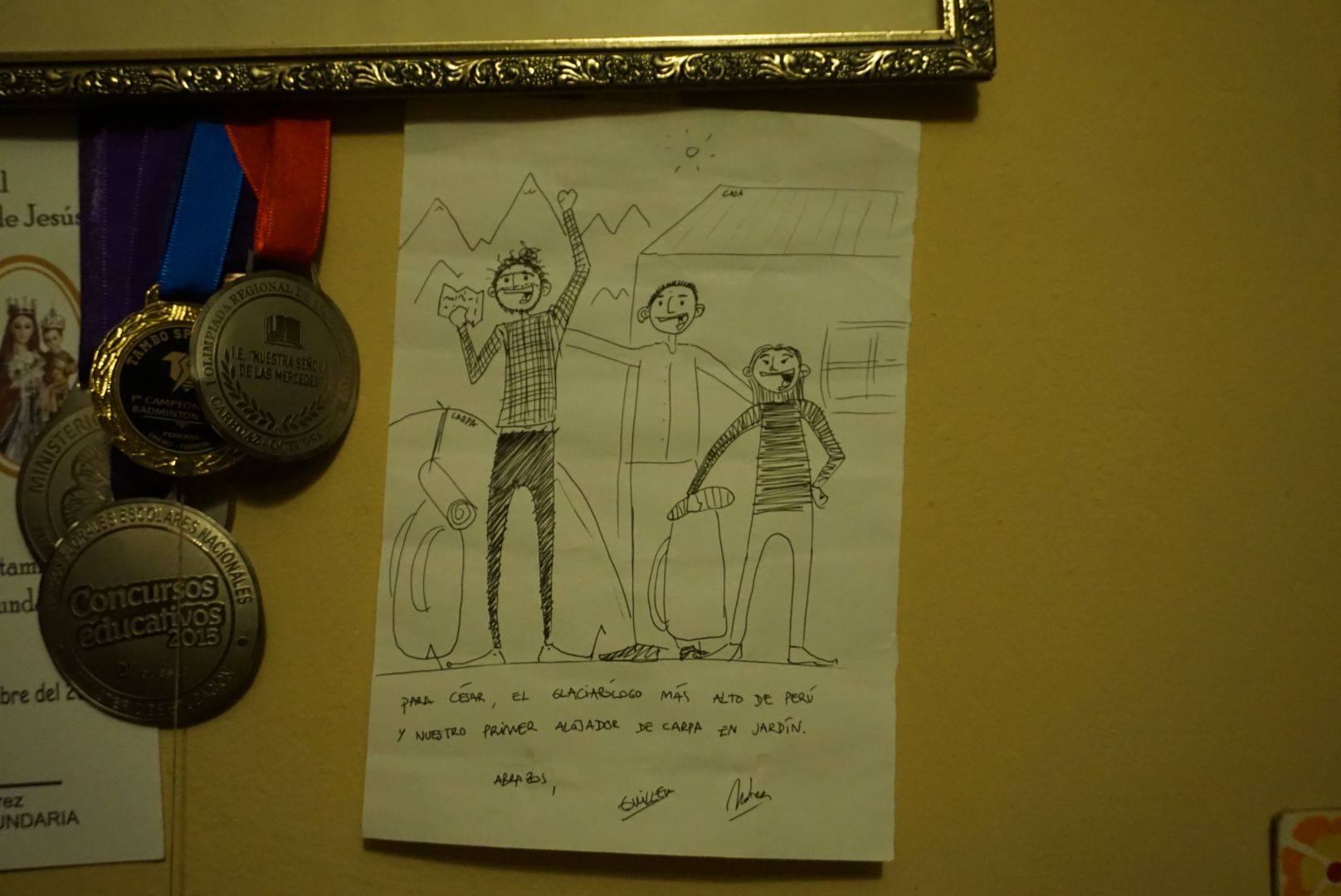 A close-up of César’s office wall: medals accompanied by a thank you note from backpackers who spent a night in César’s garden. Image by Audrey Fromson. Peru, 2019.