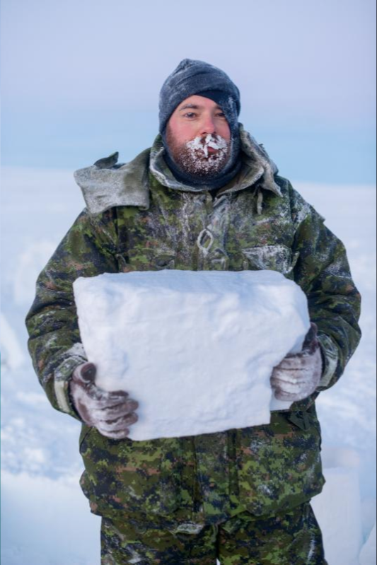 Canadian pilot Adam Schellinck has learned the proper way to cut ice blocks for an igloo. Image by Louie Palu. Canada, 2019.