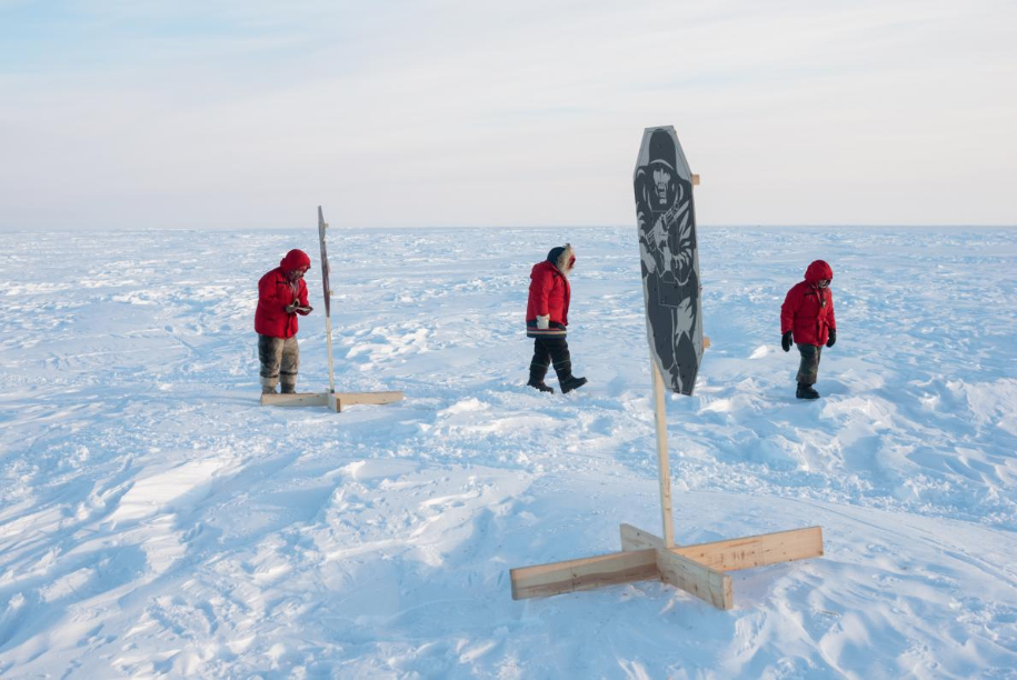 Canadian rangers inspect targets after practicing their marksmanship on a firing range. They carry rifles to protect against polar bear attacks—the greatest threat to human life, after the extreme weather. Image by Louie Palu. Canada, 2019.