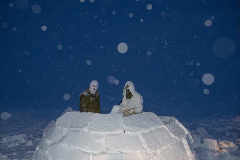 Canadian soldiers build an igloo during the high Arctic phase of their training to become Arctic operations advisers. In this part of the program, they learn to travel, survive, and build shelters when they reach the high Arctic. Image by Louie Palu. Canada, 2019.