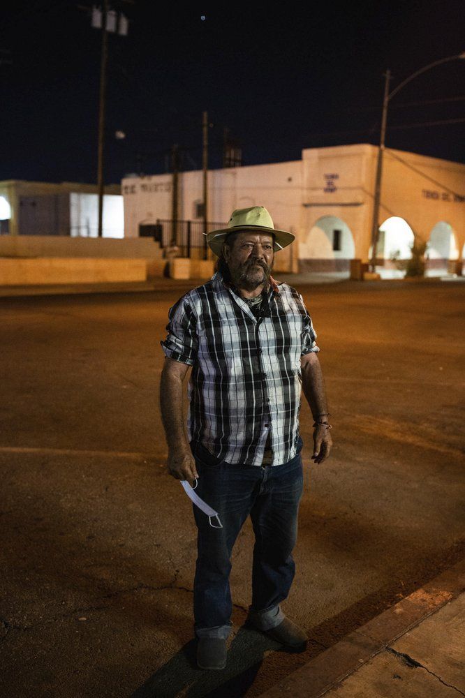 Sergio Gomes Macias stands on a street in Calexico, Calif., on July 23, 2020. Macias is a farmworker who sleeps on the street about 500 feet from the Mexican border. He says the pandemic has made it hard to find food, water and restrooms since nonessential businesses closed amid high infection rates in the area. Many homeless people work low-wage essential jobs on the front lines of the pandemic, putting them at higher risk of catching and possibly transmitting the virus. Many who work with these communities are reluctant to speak about this risk for fear of further stigmatizing homeless people, even though they do the front-line jobs others can avoid. Image by Anna Maria Barry-Jester/KHN and the Howard Center For Investigative Journalism via AP. United States, 2020.