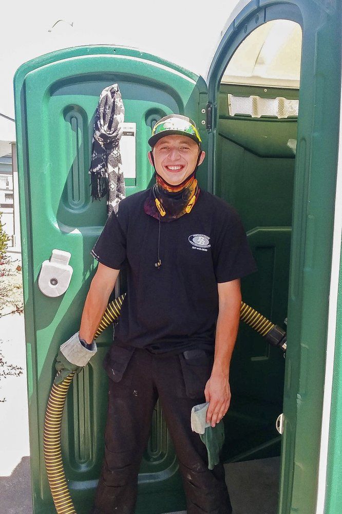 Donnie Settles, 27, stands near a portable toilet on July 14, 2020, which he services for his employer in Arcata, Calif. Settles lived at an emergency tent shelter for two months during COVID-19 while he saved up money for rent. Many homeless people work low-wage essential jobs on the front lines of the pandemic, putting them at higher risk of catching and possibly transmitting the virus. Many who work with these communities are reluctant to speak about this risk for fear of further stigmatizing homeless people, even though they do the front-line jobs others can avoid. Image by Robert Peach/Arcata House Partnership and the Howard Center For Investigative Journalism via AP. United States, 2020.