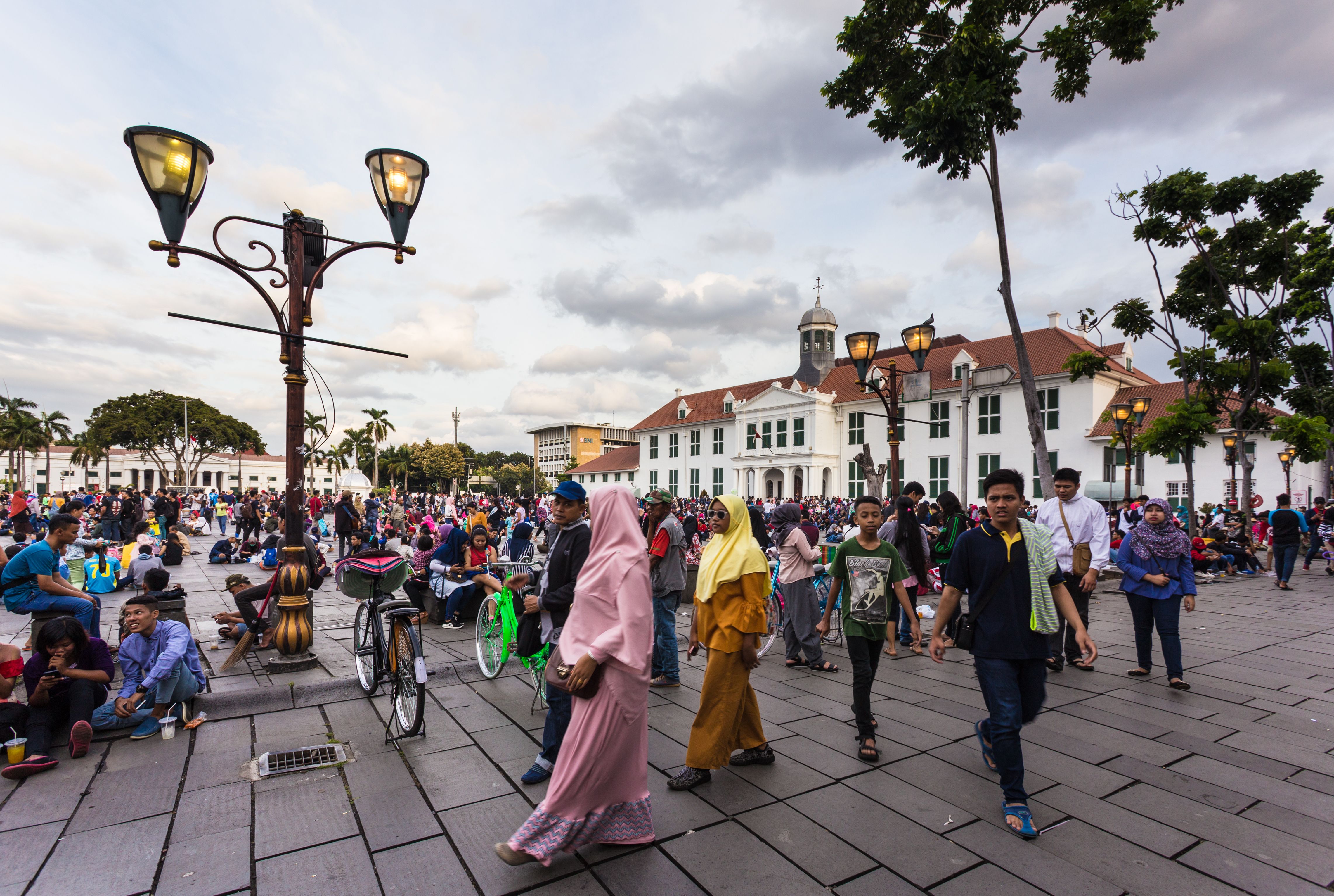 A large crowd of local people spend their Sunday afternoon around the fatahillah Square in Jakarta colonial old town named Kota. Image courtesy of AsiaTravel/Shutterstock. Indonesia, 2017.