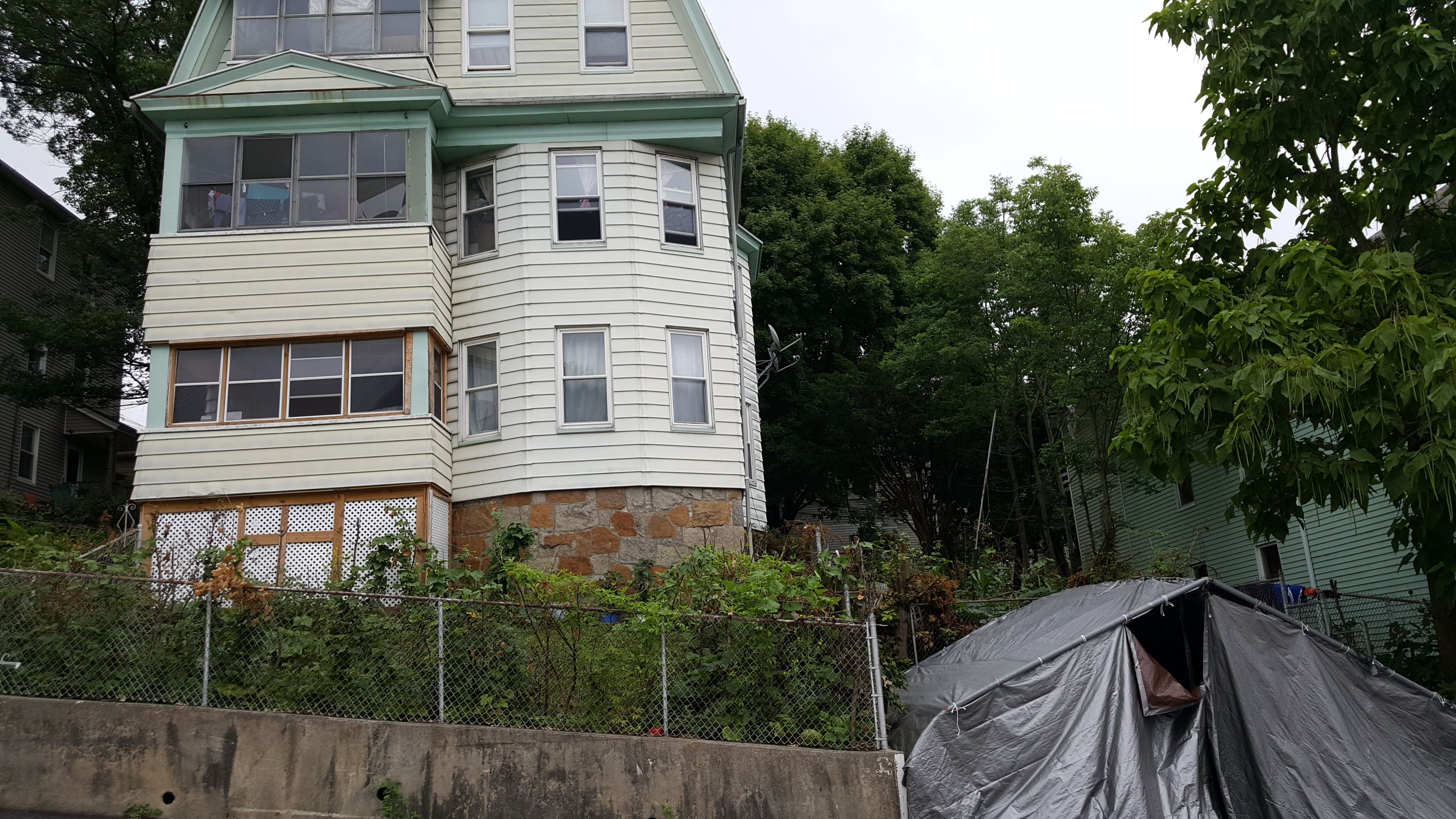 A full house with several apartments housing several different refugee families and a garden in the front. Image by Ani Gururaj. Massachusetts, 2018.