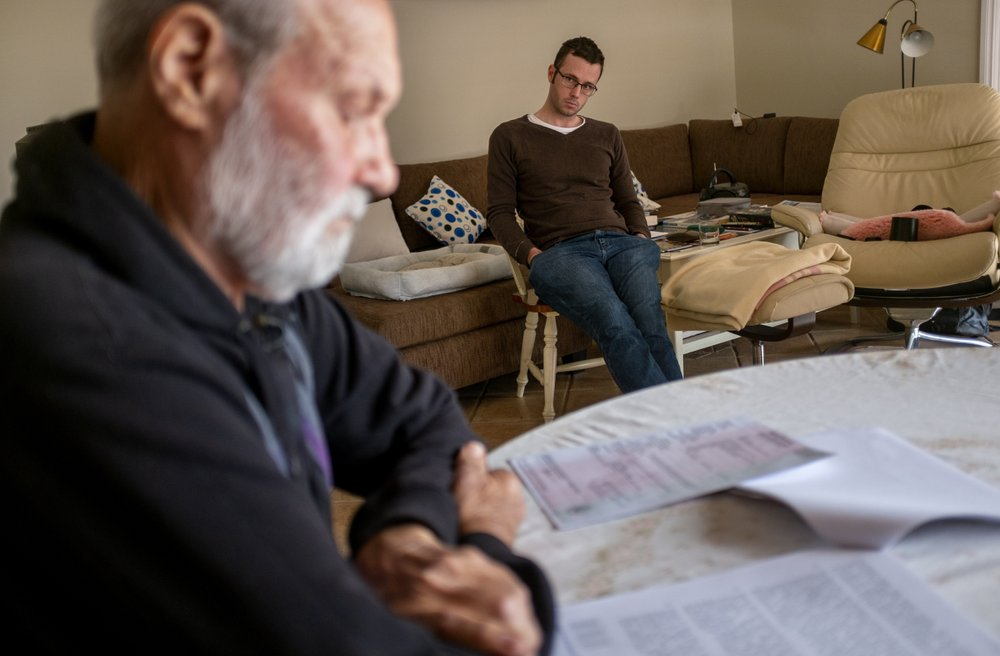 David Tonkin looks over the coroner report on his son, Matthew, as Matthew's friend, Ivo Kinshela, looks on in Perth, Australia, Sunday, July 21, 2019. Kinshela considers David a father figure. He has long been close to the Tonkin family having lived with David and Matthew for three years when he was younger. Image by David Goldman. Australia, 2019.