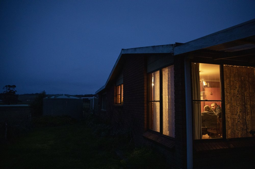 Carmall Casey, left, is visited by Jake Marshall, a friend who has recovered from an opioid addiction himself, at her home in Black River, Tasmania, Australia, Tuesday, July 23, 2019. Here in Tasmania, there are echoes of American Appalachia, in the rural towns, the poverty and the cascade of lives torn apart by pills that promised to take away the pain but in the end created more. Image by David Goldman. Australia, 2019.