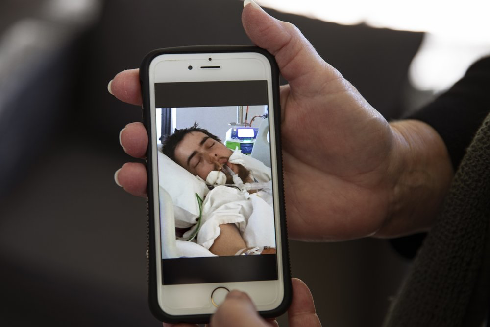 Deb Ware shows a photo she took of her son, Sam, 22, on life support from an overdose, in Fountaindale, Central Coast, Australia, Thursday, July 18, 2019. This was hardly the first overdose Sam had experienced since his addiction to pharmaceutical opioids began following a simple wisdom tooth extraction. But she wondered if it would be his last. He had somehow survived more than 60 overdoses in 12 months. Image Courtesy of David Goldman. Australia, 2019. 