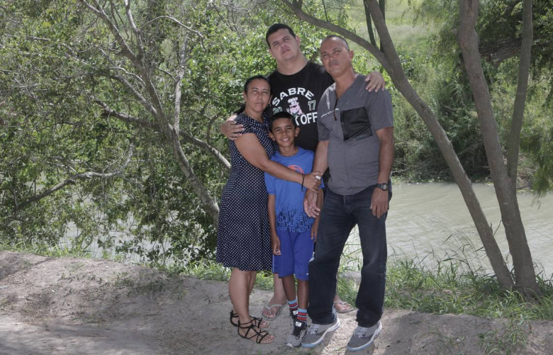 Clockwise from left to right: Mairen Barbara Almora, Abel Aguilar Almora (21 years old), Abel Aguilar Columbie, Sergio Almora (9 years old), pose for a photo by the Rio Grande on the Mexican side of the border. Image by Jose A. Iglesias. Mexico, 2019.