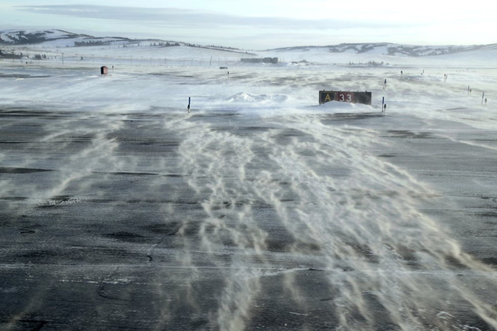 In this Feb. 15, 2019, photo, winds carry snow across the tarmac of the Unalakleet Airport in Alaska. The airport is a common stop between Nome and villages to the south. Image by Wong Maye-E. United States, 2019.