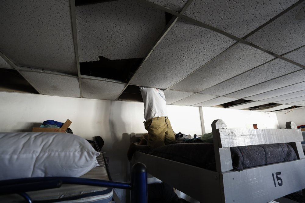 In this July 31, 2019, photo, a man from Africa uses the ceiling space above his bunk to store his valuables at El Buen Pastor shelter for migrants in Cuidad Juarez, Mexico. Image by Gregory Bull. Mexico, 2019.