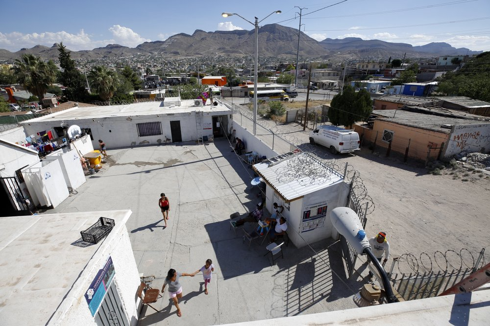 In this July 30, 2019, photo, people walk through the patio at El Buen Pastor shelter for migrants in Cuidad Juarez, Mexico. Image by Gregory Bull. Mexico, 2019. 