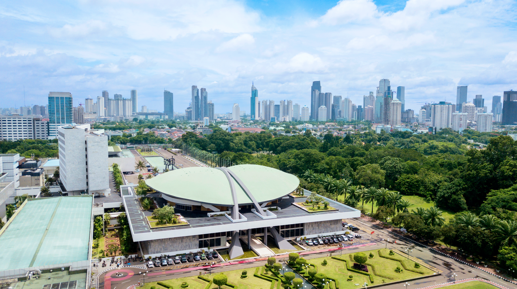 Aerial Image of the Indonesia Parliament Complex, also known as the DPR / MPR building, with Jakarta's cityscape at midday. Image by  Creativa Images / Shutterstock. Indonesia, 2018.