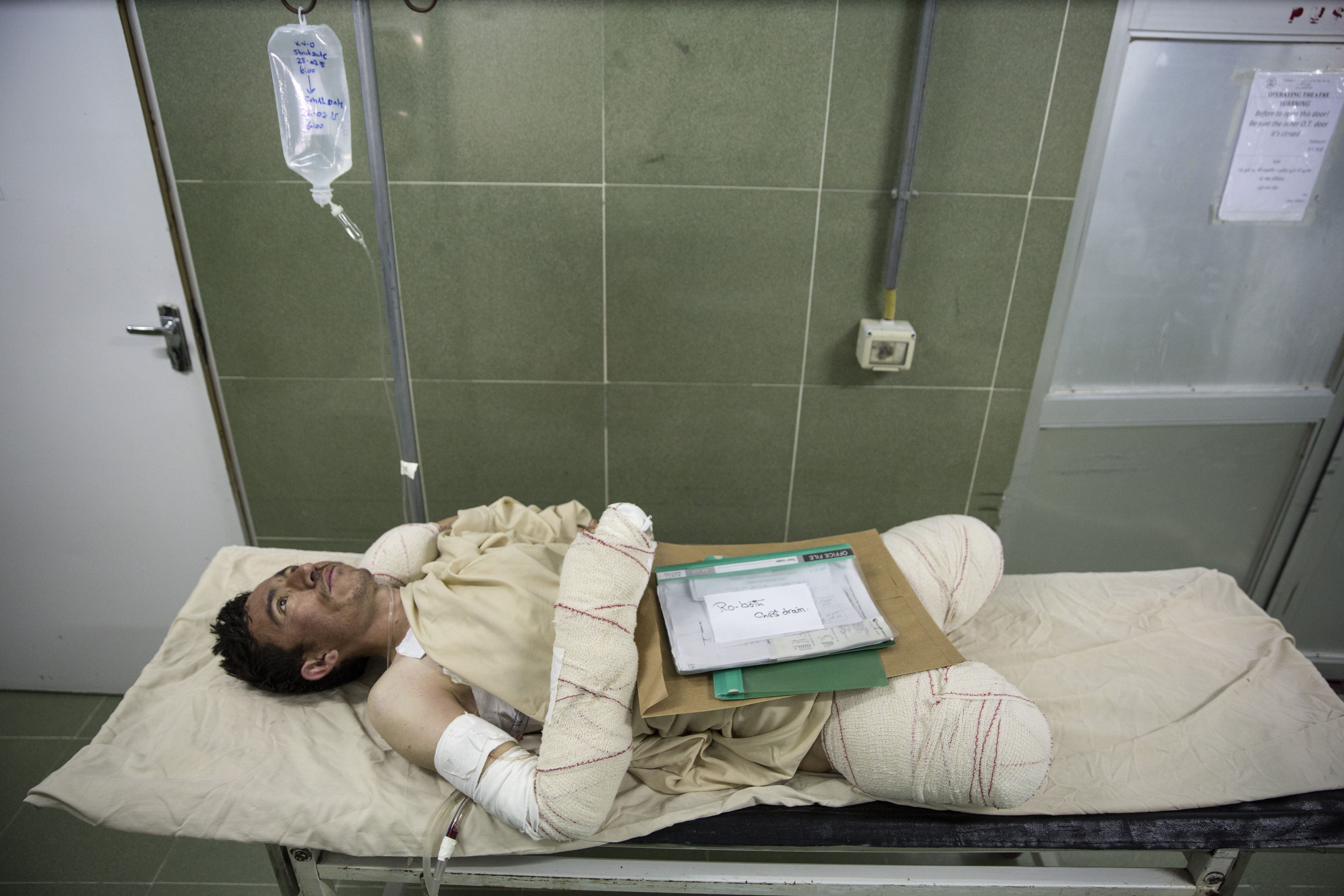 Sayed Malik, a soldier in the Afghan National Army, awaits surgery after losing both his legs while de-mining in Sangin. Image by Paula Bronstein. Afghanistan, 2015. 