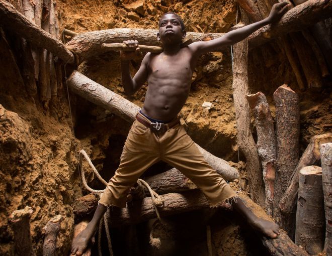 Nine-year-old Karim Sawadogo stands on bracing timbers inside one of the many gold pits at the Kouékowéra mining village in southwestern Burkina Faso. Image by Larry C. Price. Burkina Faso, 2013.