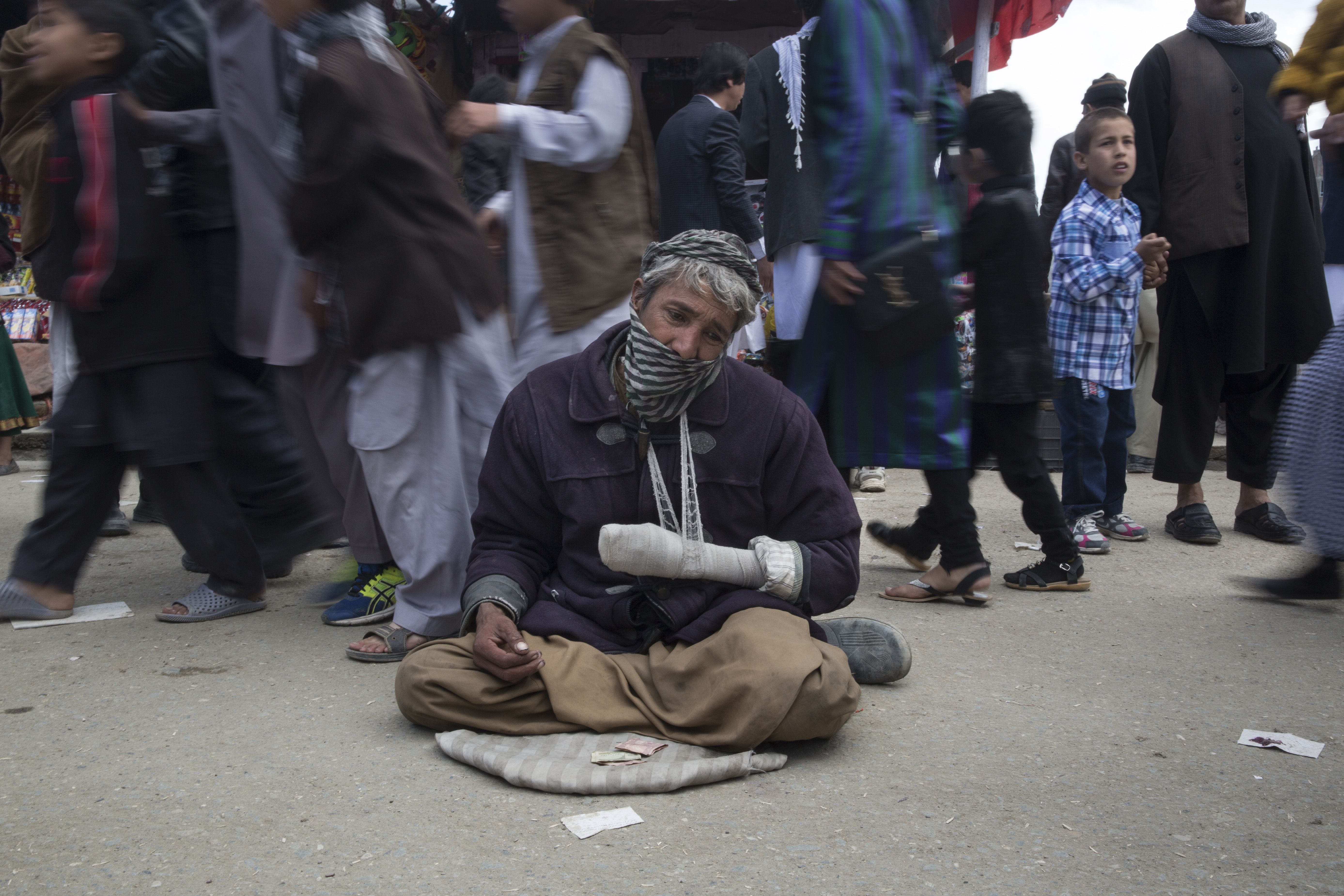 Ibrahim, a mine victim, begs on the street during Nowruz, the Afghan New Year Festival. Image by Paula Bronstein. Afghanistan, 2015. 