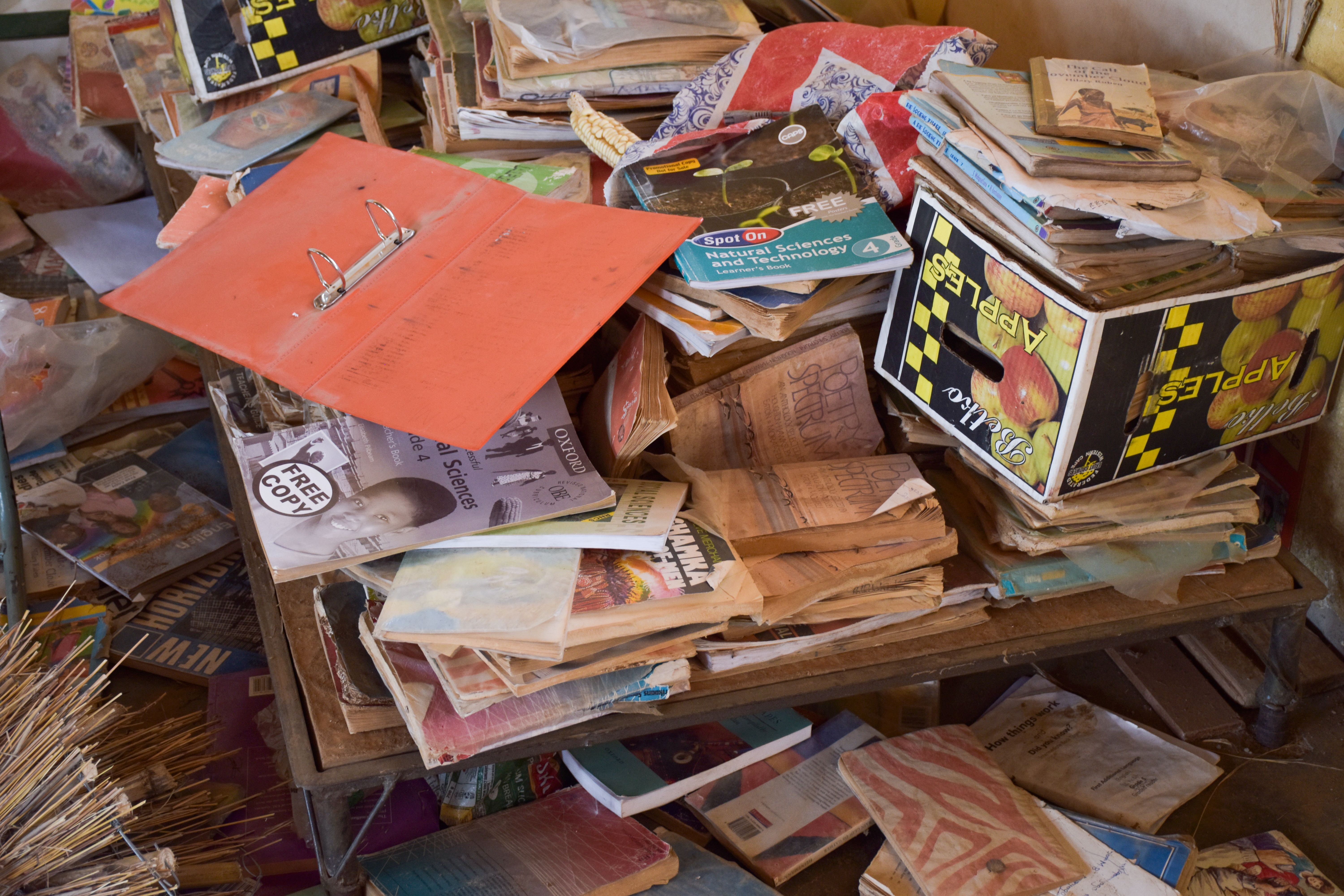 A pile of old textbooks and novels that are no longer used at Utjane. Utjane, like many rural schools, lacks a usable library. Image by Adam Yates. South Africa, 2018.