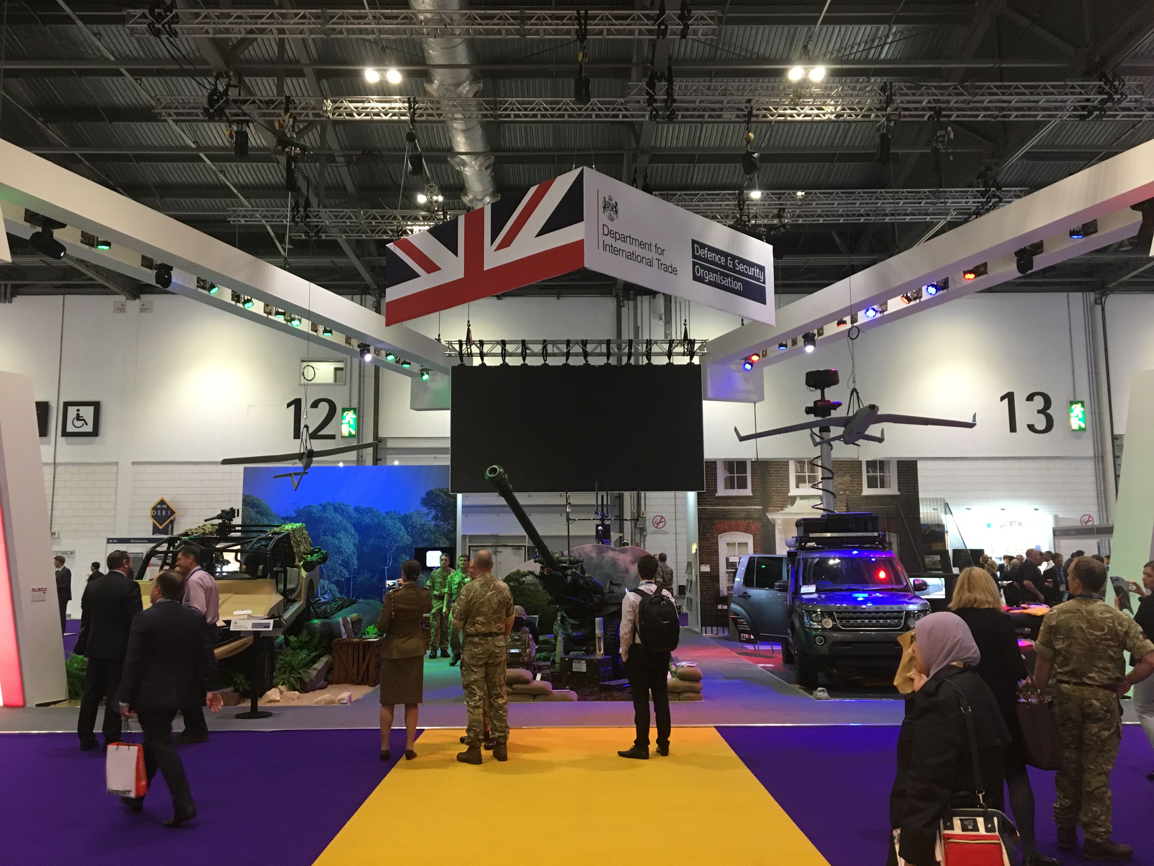The British quarter at the world's largest arms fair, DSEI in London. The Defence & Security Organisation, a taxpayer funded organ of the UK government, has its logo raised high - it ploughs significant sums into promoting British arms companies exports around the world, including organising arms fairs. Image by Matt Kennard. United Kingdom, 2017. 