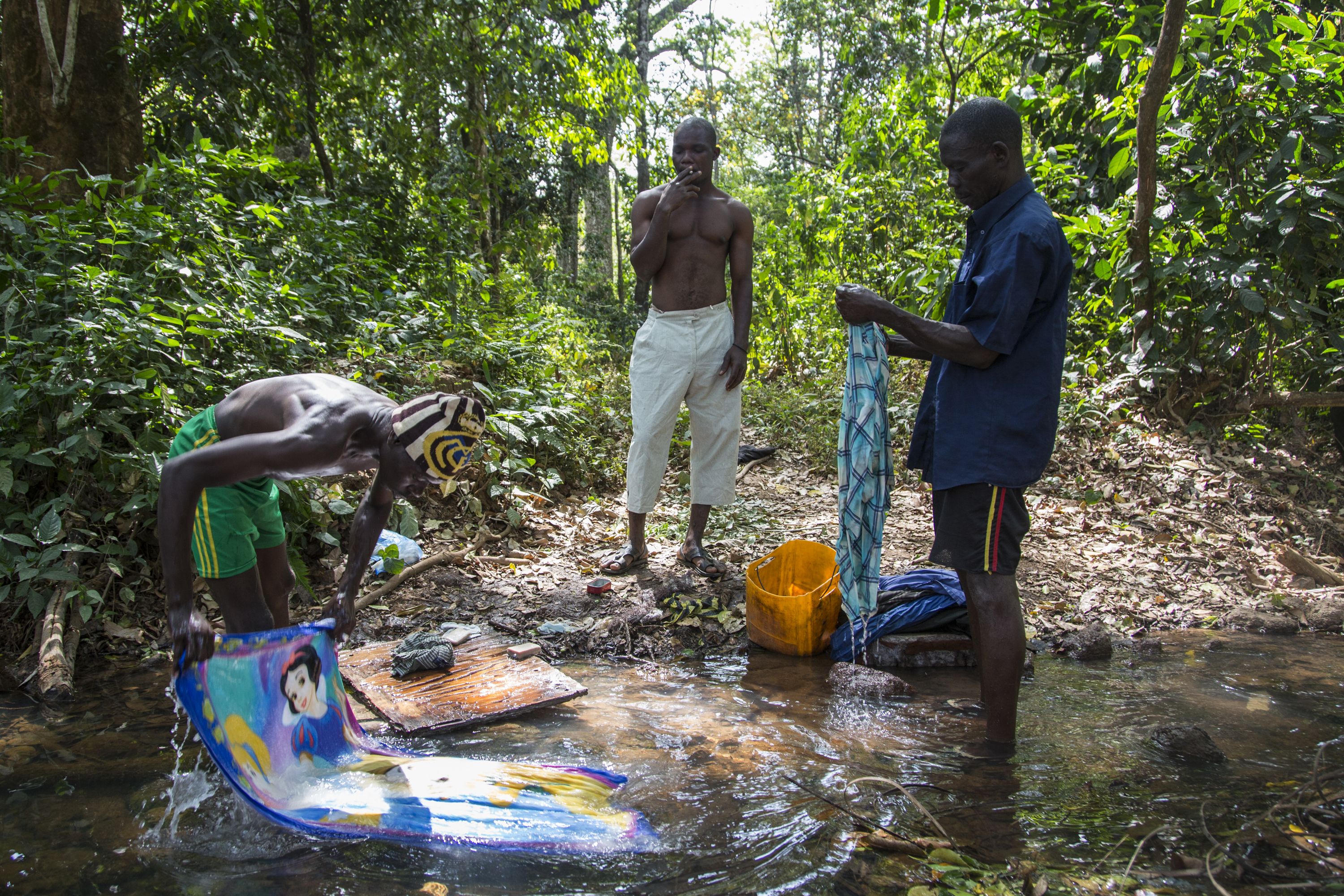 Chinko employees wash their clothes and other belongings in a stream near the park's main base. Image by Jack Losh. Central African Republic, 2018.