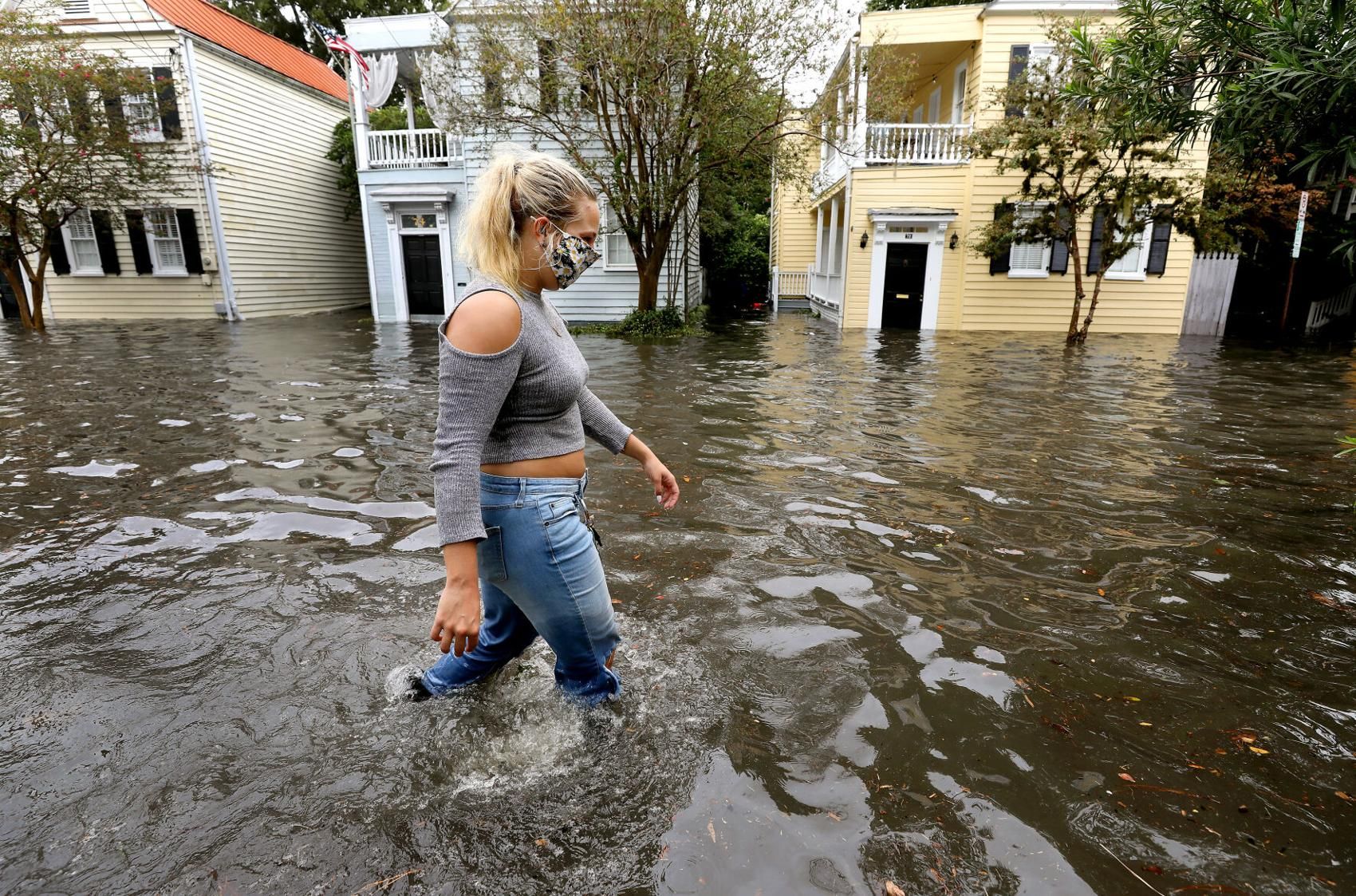 Kirstin Janssen walks through the flooded Vanderhorst Street on Friday, Sept. 25, 2020, in Charleston. Image by Grace Beahm Alford/Post and Courier Staff. United States, 2020.