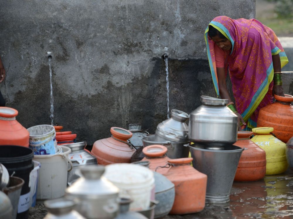 People in the Indian farming village of Dapegaon leave water jugs in line overnight and return at dawn to fill up before the daily supply of water runs out. The village relies on a single well, and shortages have worsened over the past several years as groundwater levels have declined. Image by Steve Elfers. India, 2015.