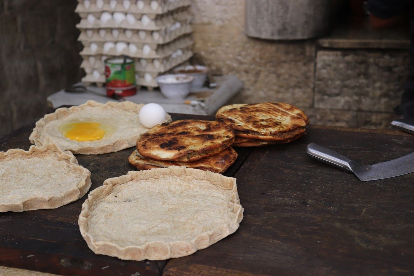 Palestinians eat qarib albyd and manaeesh daily. The former means egg boat, a literal description of the two eggs cracked into a wheat pastry crust and blitzed in a blazing hot oven. The latter is basically Palestinian pizza, a circular flatbread that can be covered with a wide variety of toppings. Here, a simple but timeless version—za’atar with jibneh. Image by Carly Graf. Palestine, 2019.