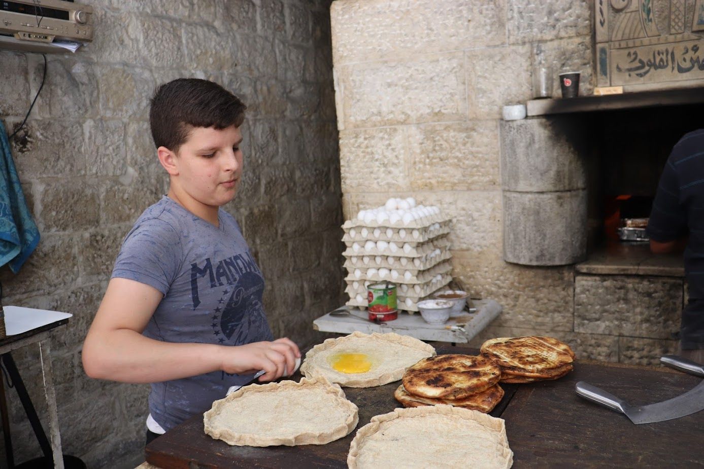 Abu el Majad has been an icon in the market for over 60 years, using the traditional wood-fired oven to create breakfast and lunch dishes perfect for quick eating. Today, it’s owned and operated by Samir Shami, who has taught his son these classic recipes. Image by Carly Graf. Palestine, 2019. 