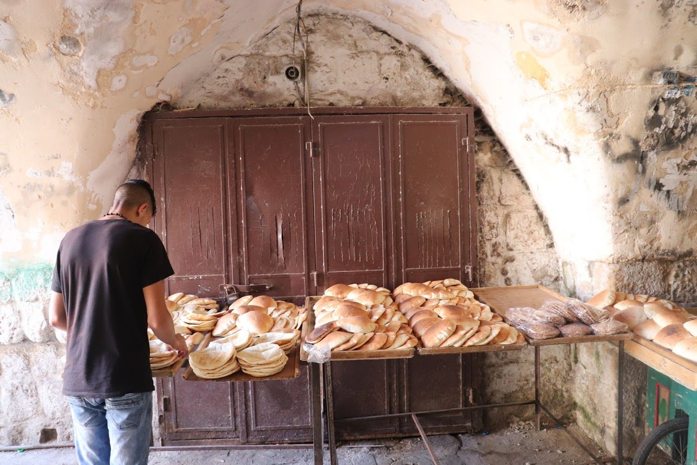 Bakeries stack carts high with freshly baked bread, steering them throughout the market to sell to shoppers. Image by Carly Graf. Palestine, 2019.