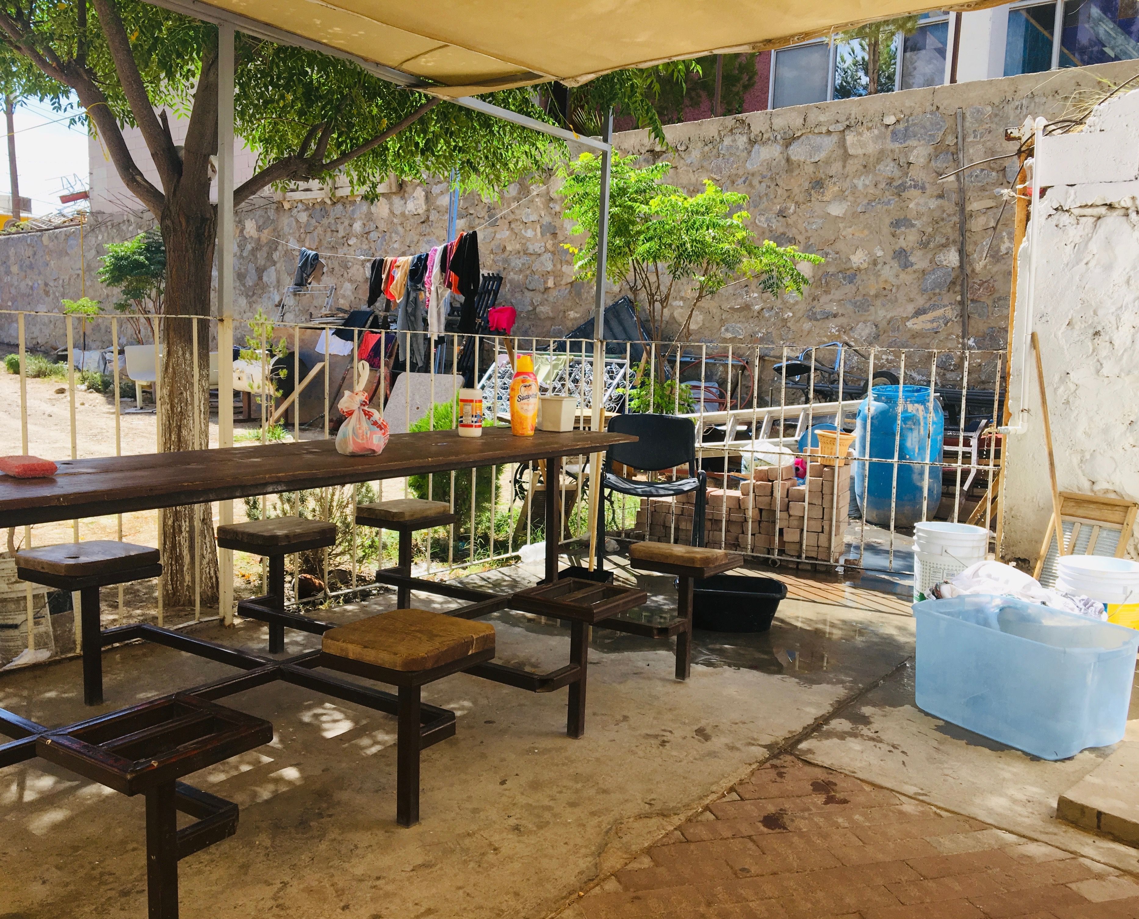 The patio outside a shelter in Ciudad Juárez. Migrants from Central America and Cuba gather here to socialize and wash their clothes at the outdoor spigot. Image by Lily Moore-Eissenberg. Mexico, 2019.