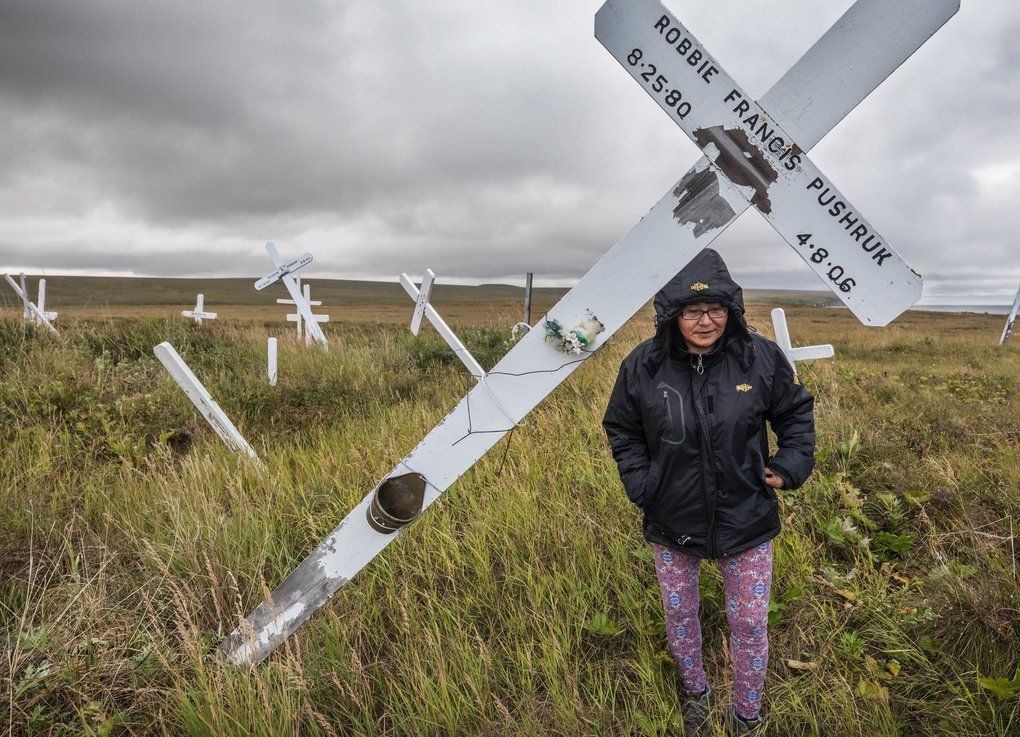 Melting permafrost is changing the landscape of northern Alaska. In the village of Teller, Carolyn Oquilluk walks through a graveyard, where the markers have tilted as the ground has shifted. Image by Steve Ringman. United States, 2019.