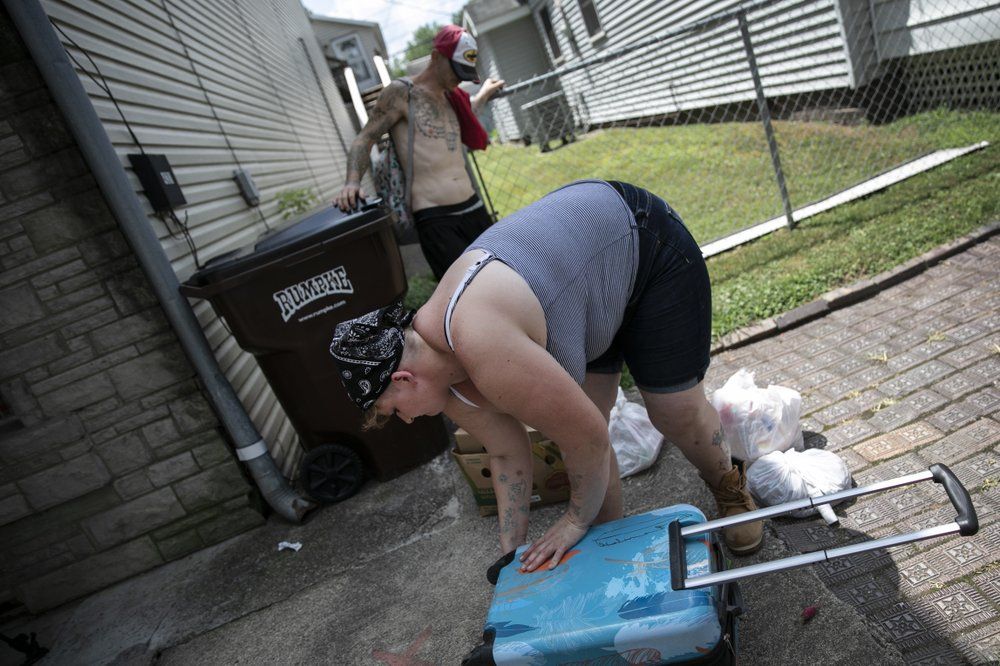 Brittany Cunningham 31, fills her suitcase with food donations accompanied by her fiance in Nelsonville, Ohio, on Friday, July 24, 2020. Brittany, a heroin addict, has been homeless for ten years. Image by Wong Maye-E/AP Photo. United States, 2020.