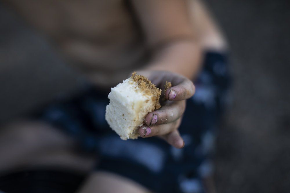 Brittany Cunningham's nephew eats a piece of cheesecake they received from a food pantry in Nelsonville, Ohio, on Friday, July 24, 2020. Brittany, a heroin addict, has been homeless for ten years. Image by Wong Maye-E/AP Photo. United States, 2020.