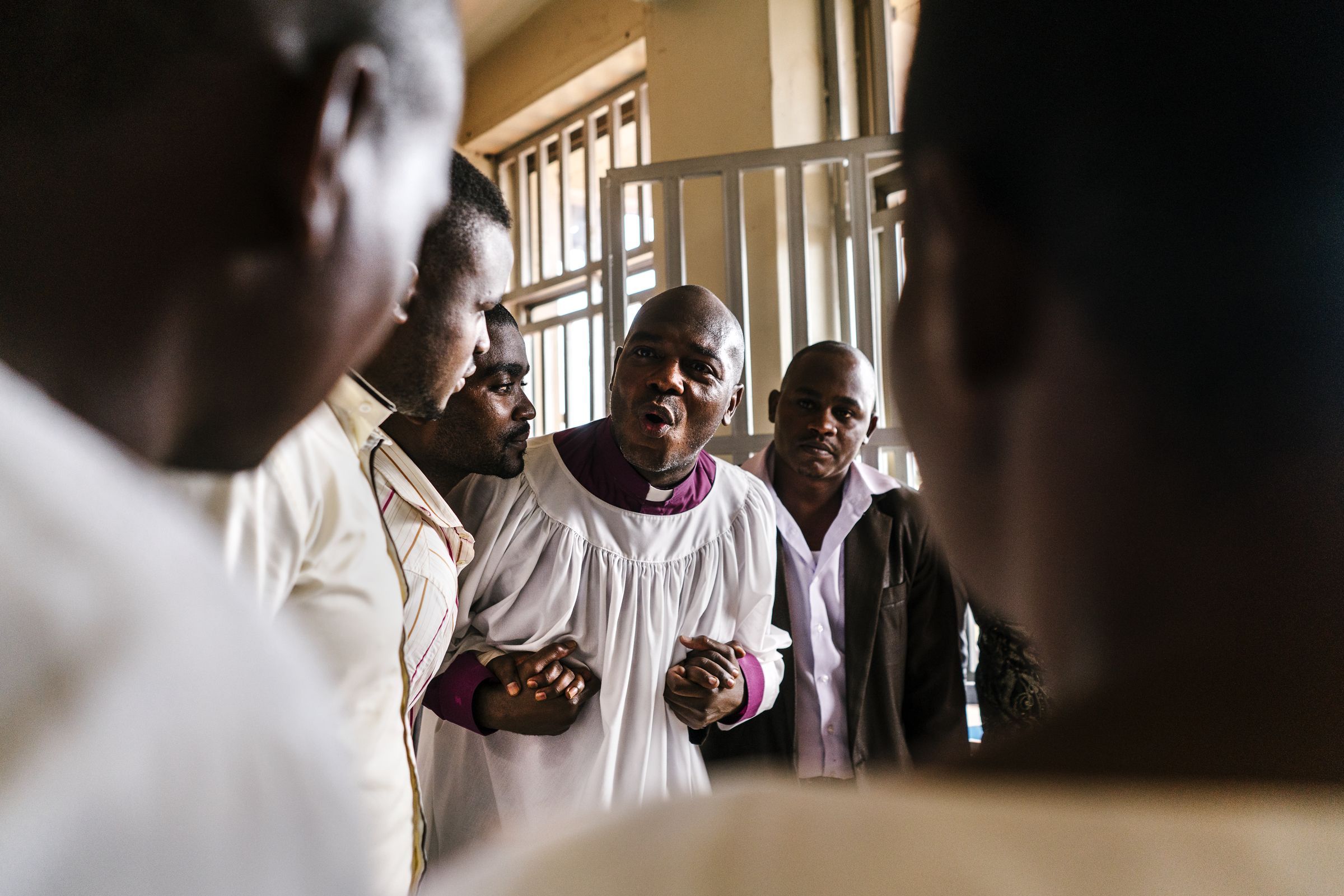 Tolton speaks with Ugandan pastors after a church service. Image by Jake Naughton. Uganda, 2017.
